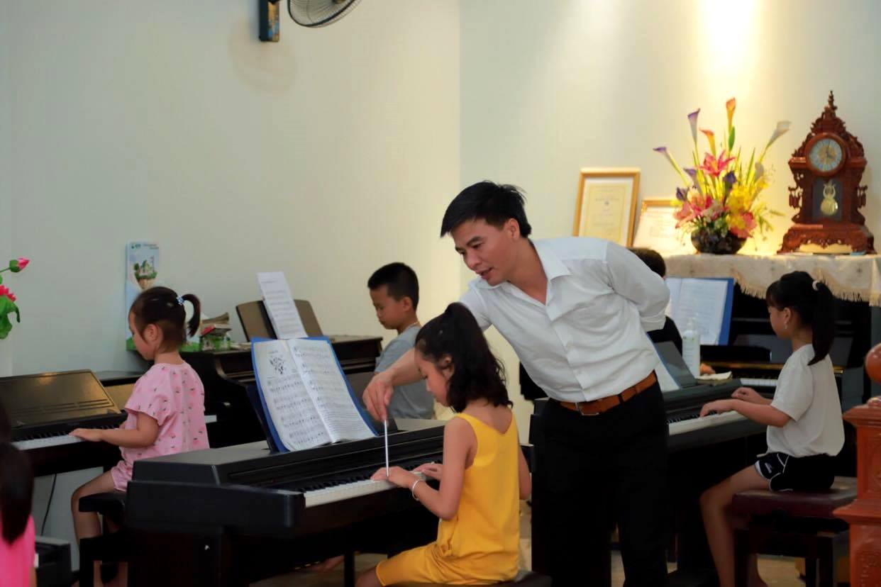 Nhạc sỹ Tô Văn dạy đàn piano cho các em học sinh tại Trung tâm Piano Lai Châu do anh làm chủ. 